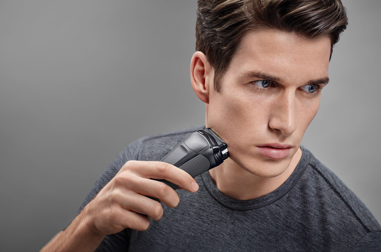 A man shaving his chin with dark tshirt