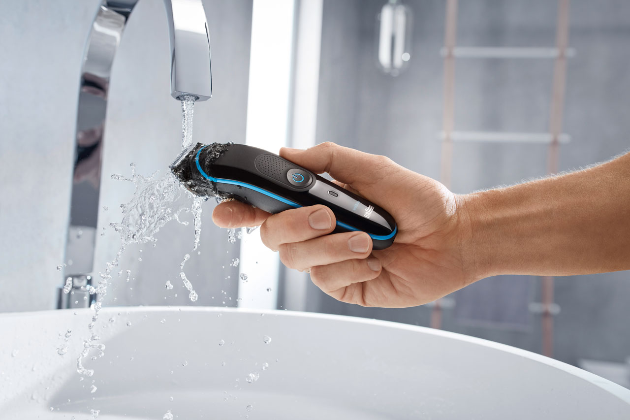 Man washing his shaver under the sink